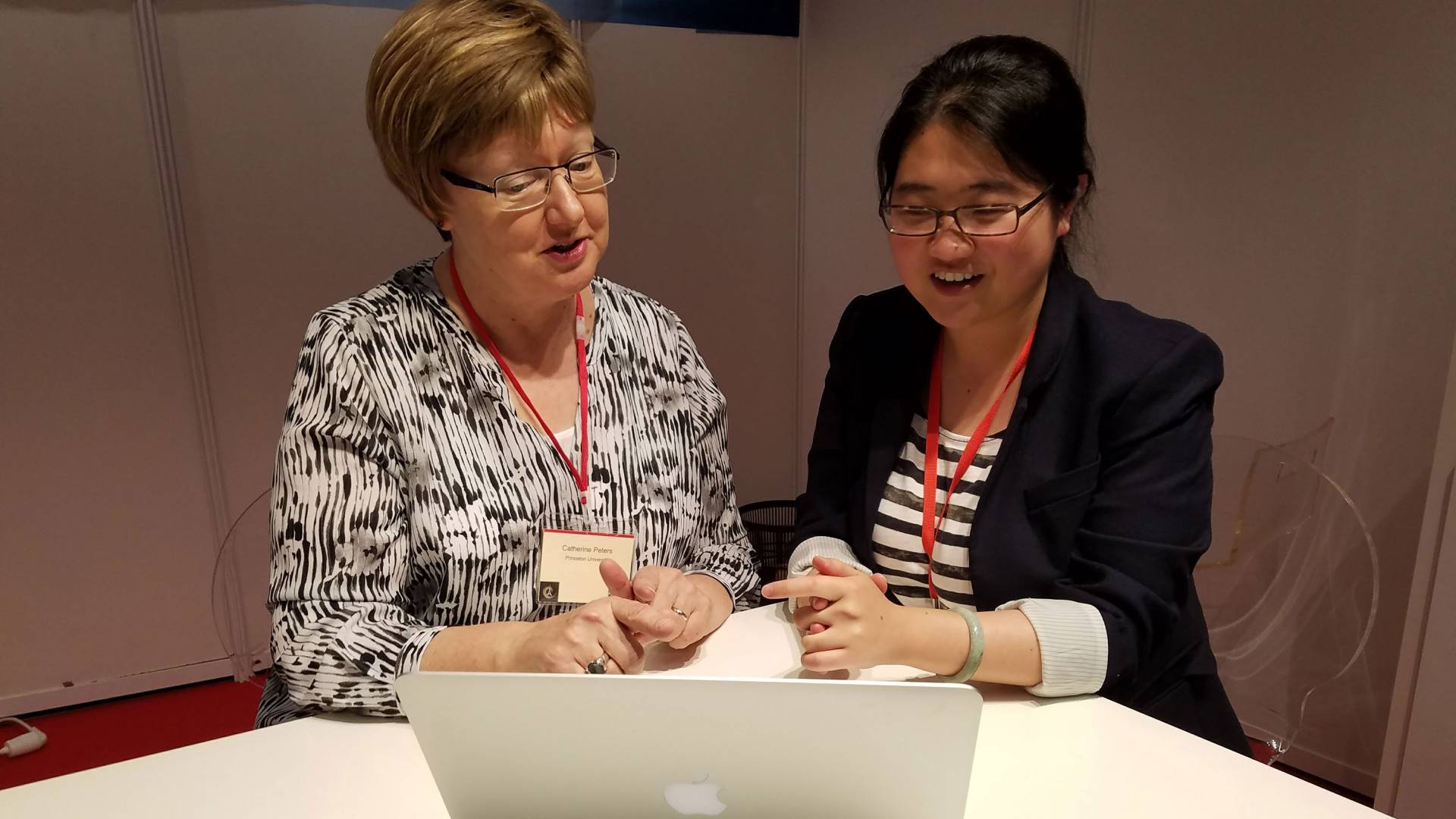 Catherine Peters and Hang Deng sit in front of computer
