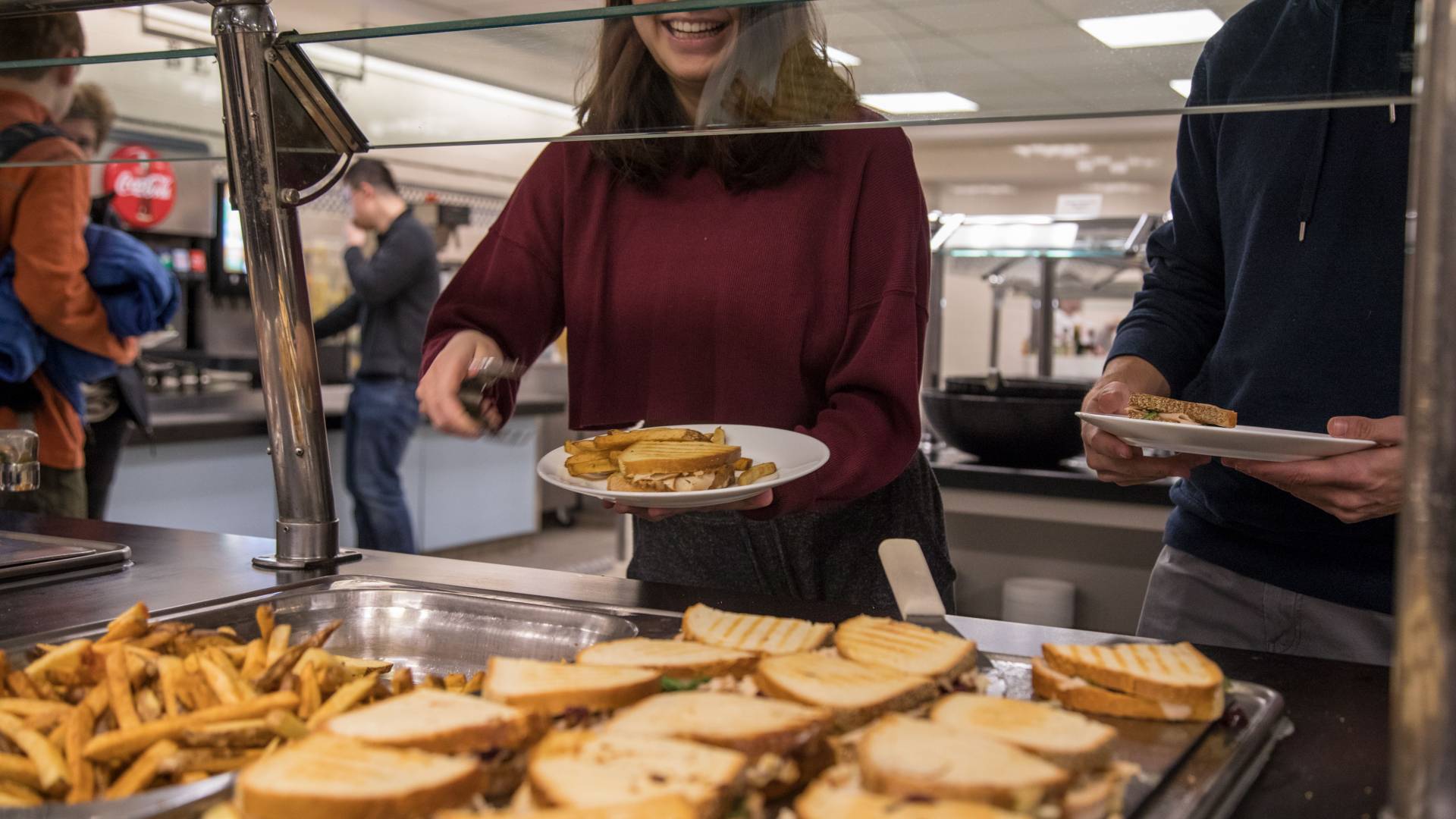 Student putting food on plate 