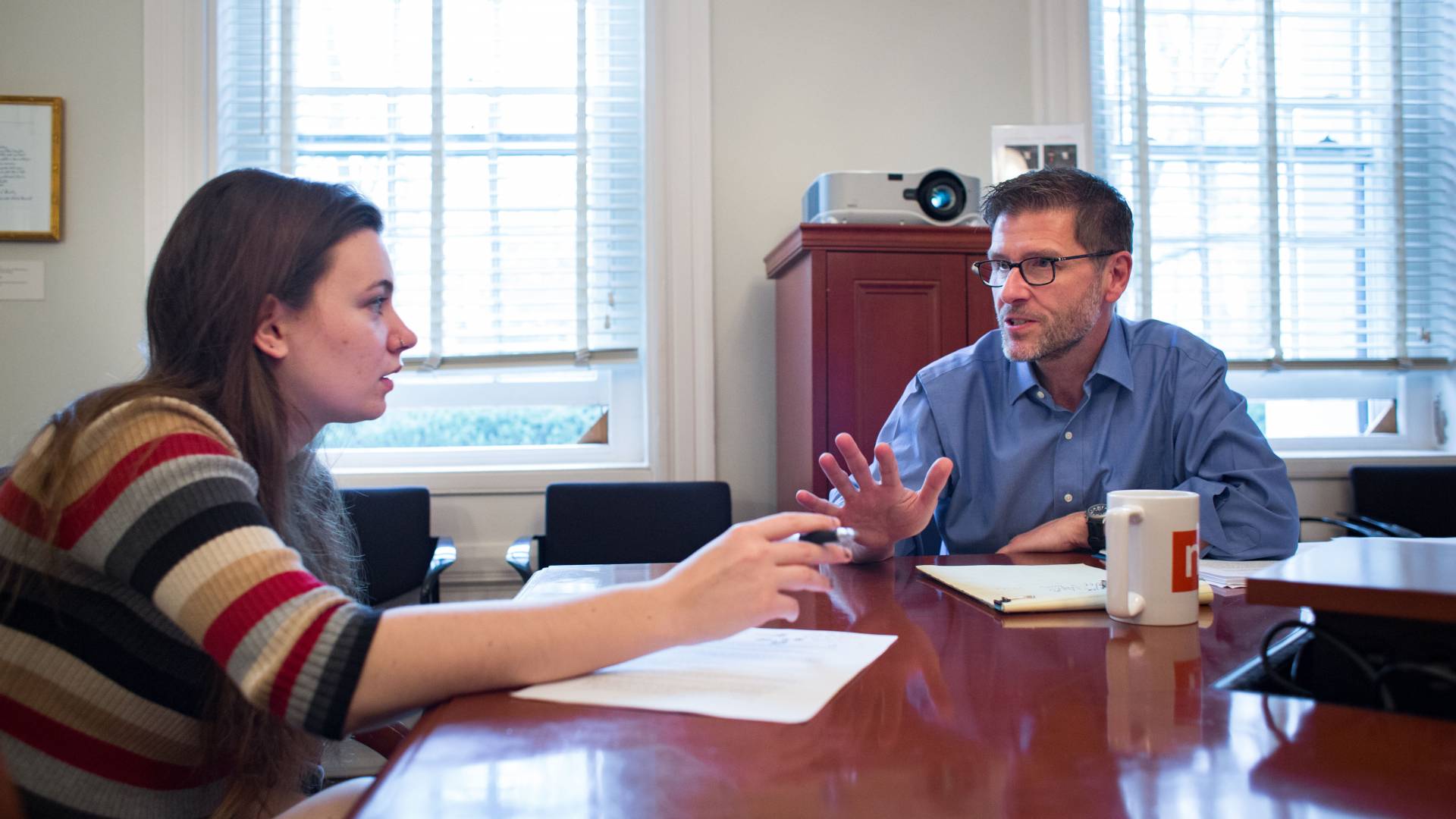 Joe Stephens talks with a student at a table