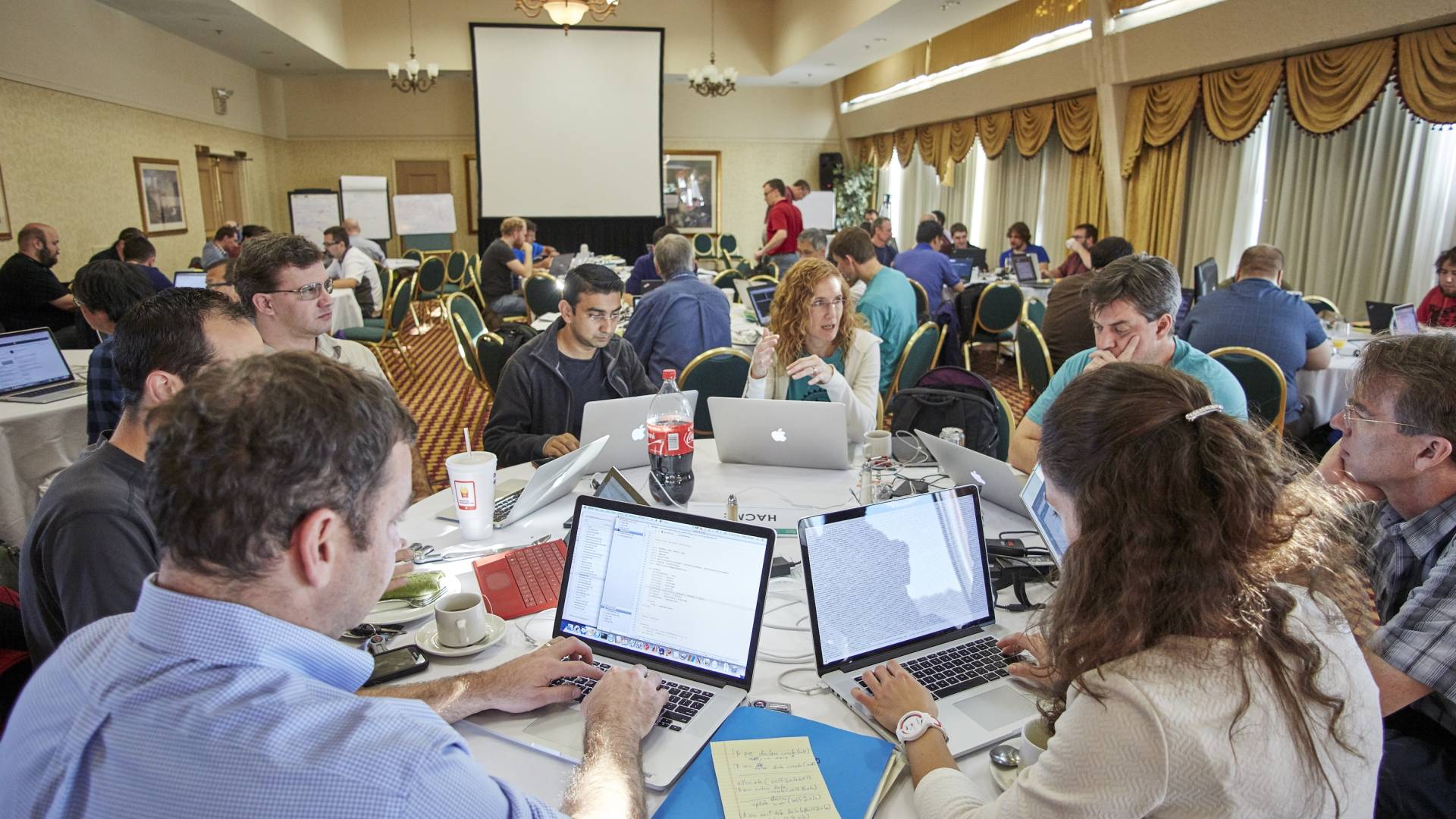 GPU hackathon participants on computers around a table