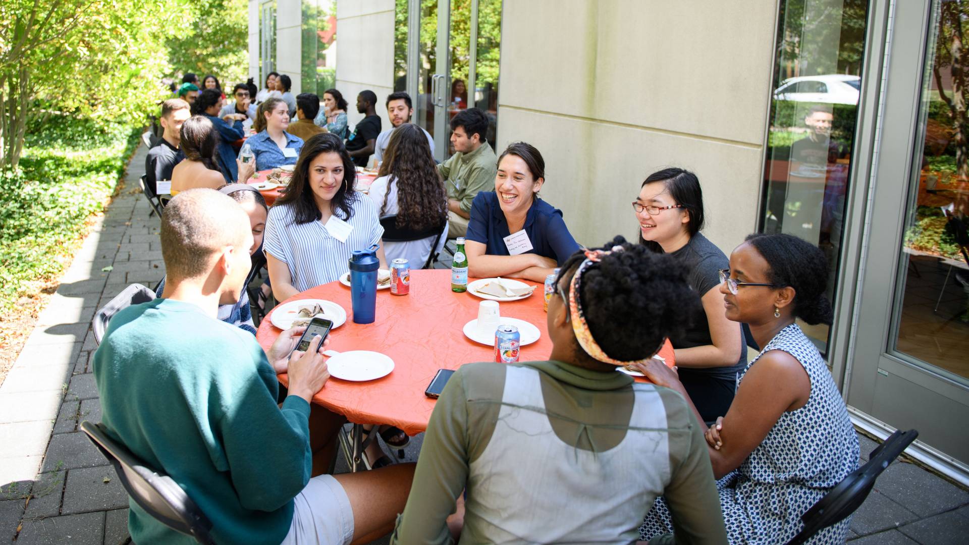 Students sitting around tables outside