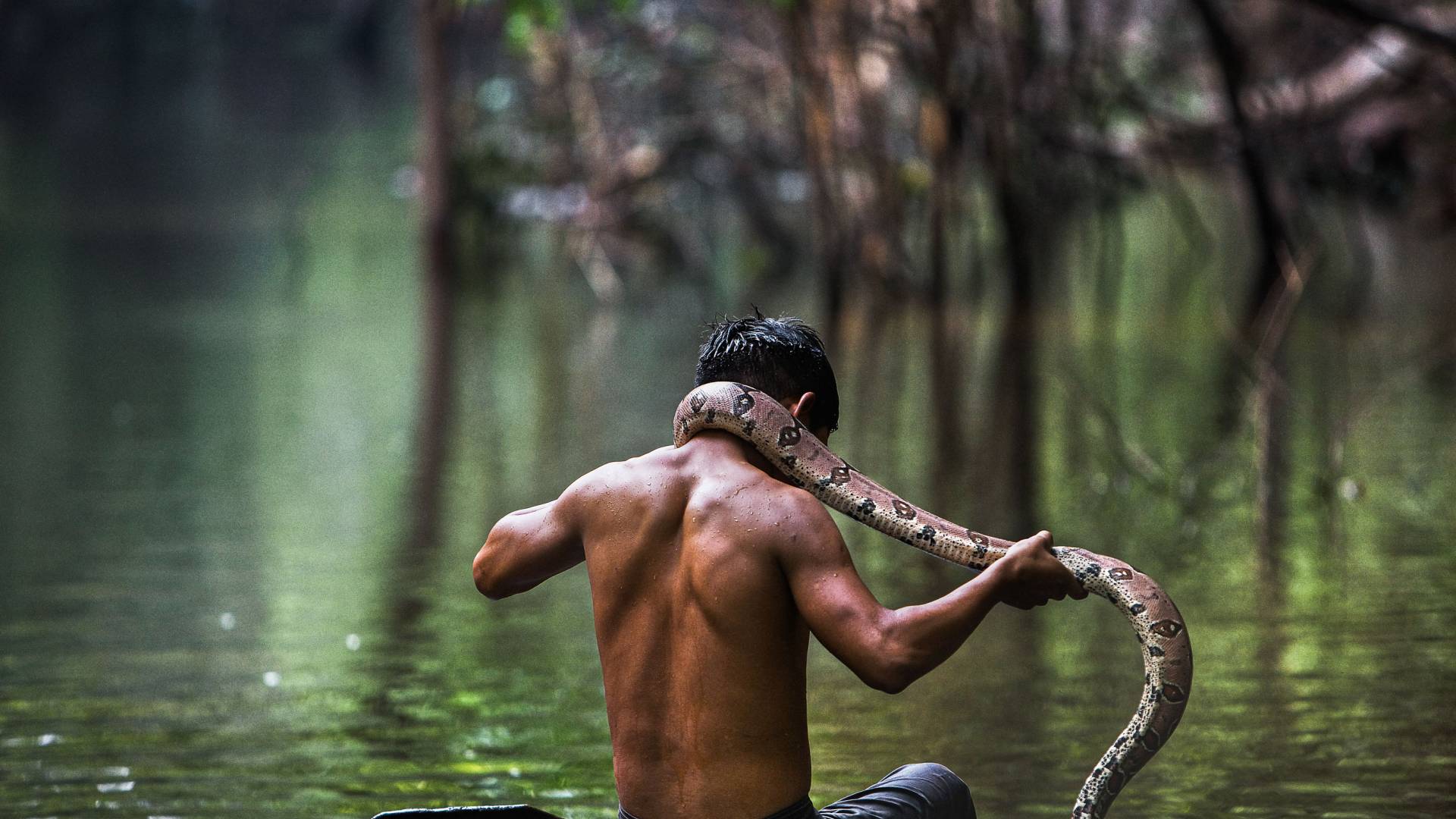 A man on a boat with a snack hanging on the back of his neck