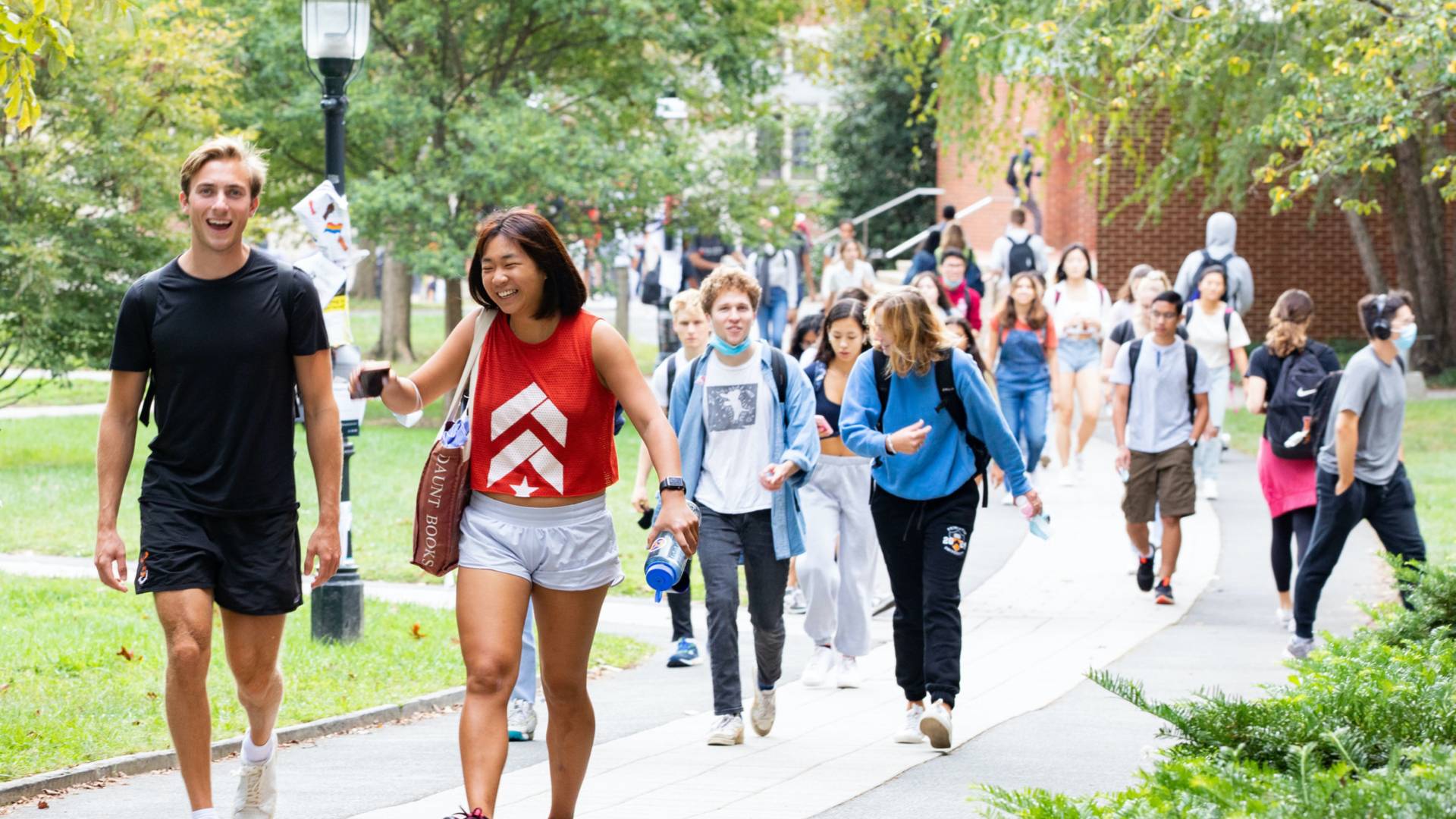Students laughing as they walk across campus