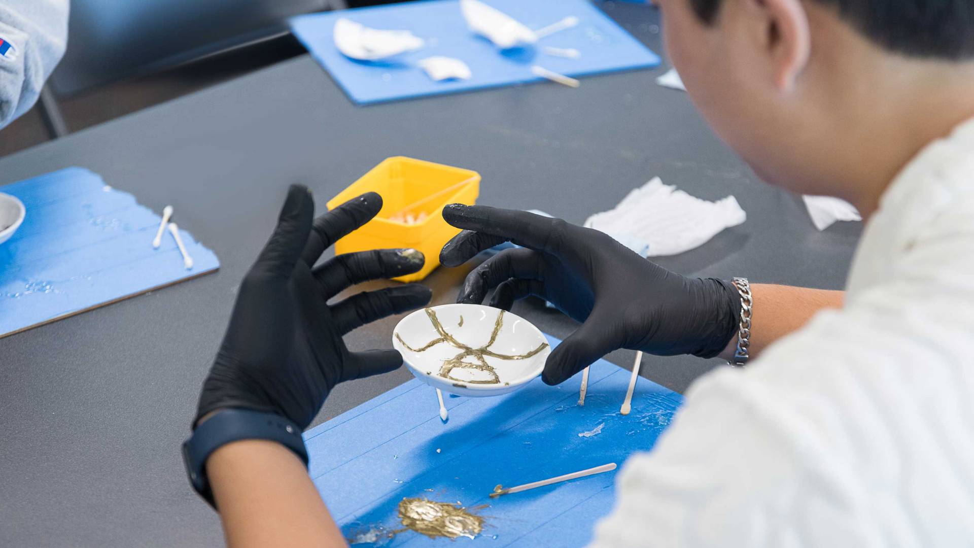 Students repair broken pottery with a Japanese techinque
