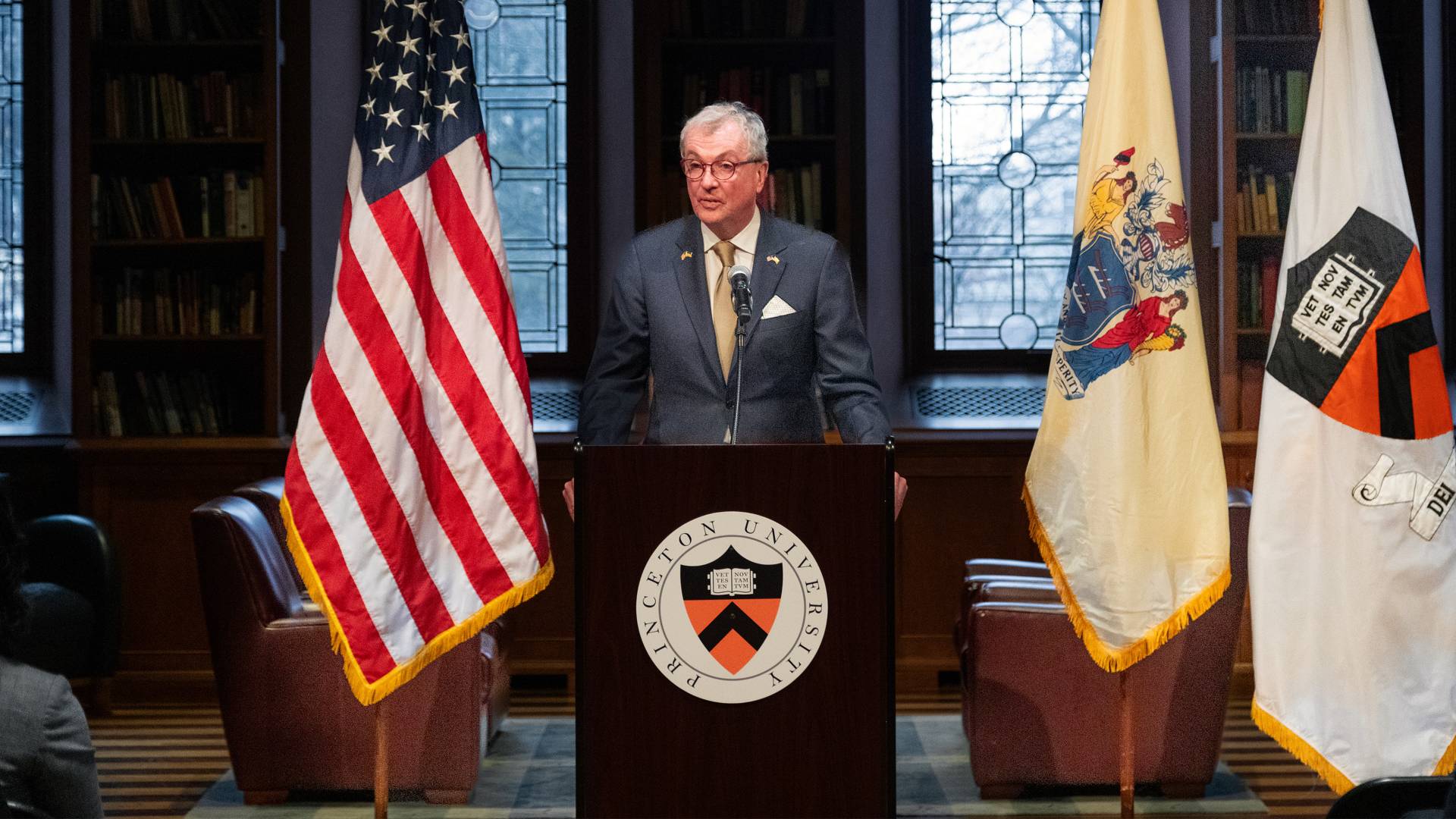 New Jersey Governor Phil Murphy standing in front of a podium in the Chancellor Green Library in front of a large audience