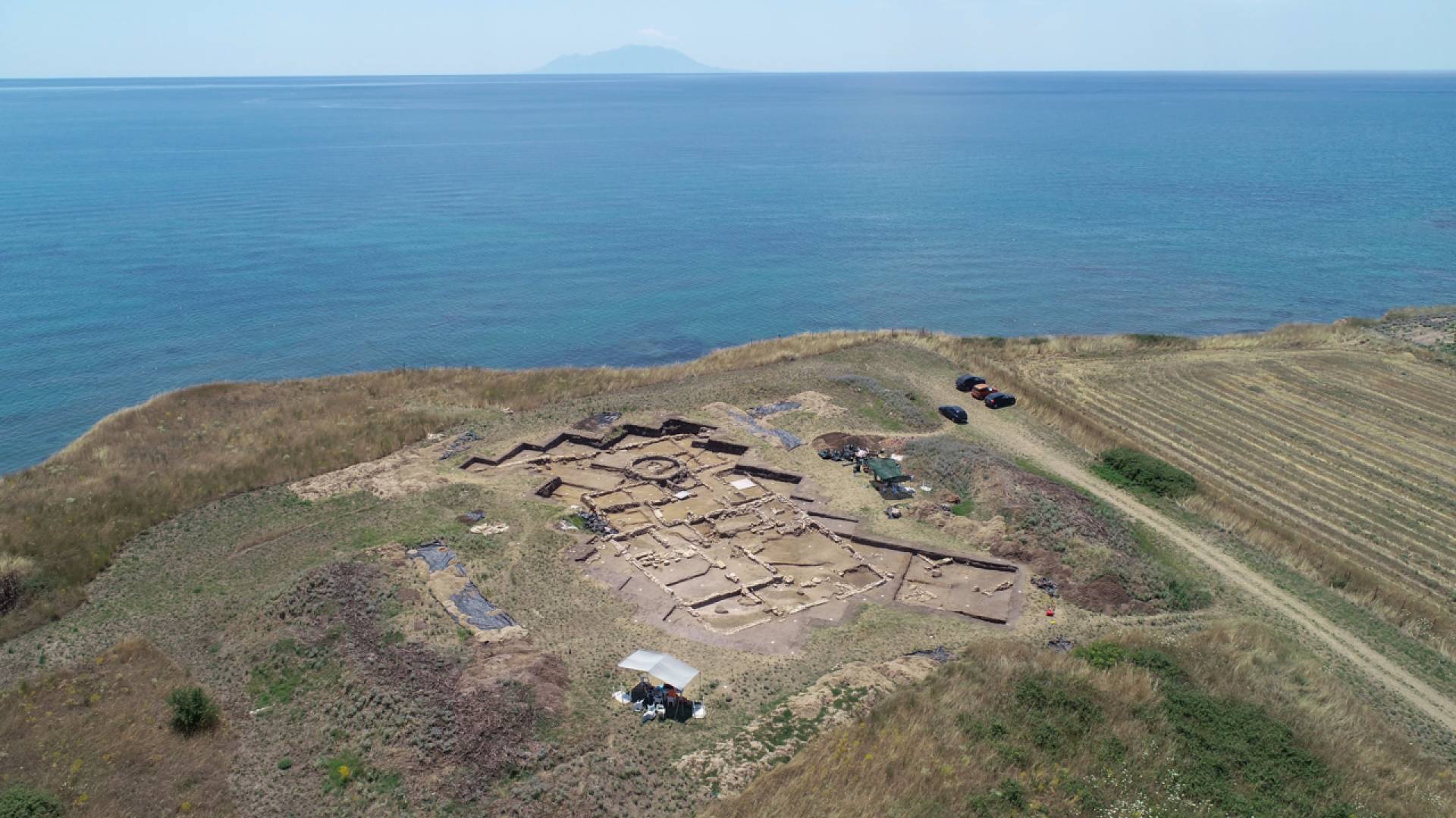 A high-altitude view of a dig site overlooking a large body of water.