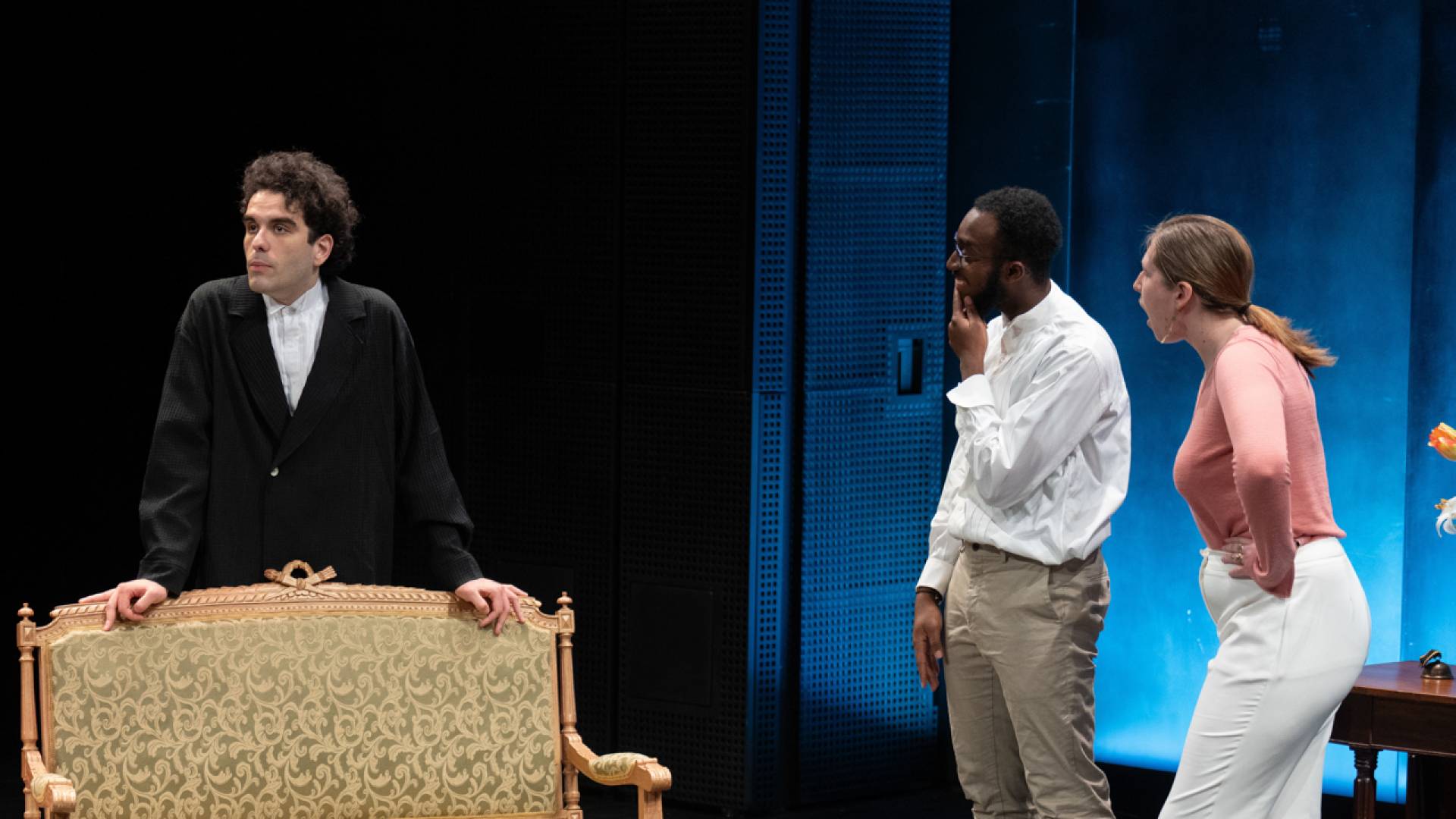 Three actors on stage in converstation.