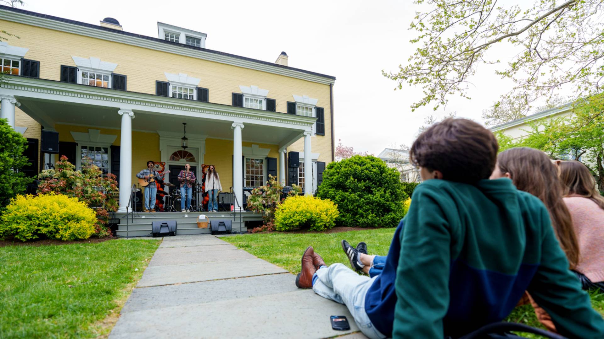 A man sitting on the ground while watching a performance.