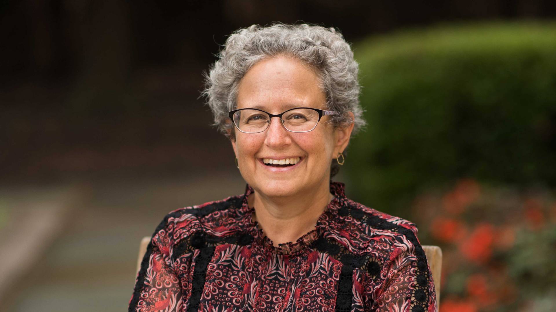 Melissa Lane smiling in a garden