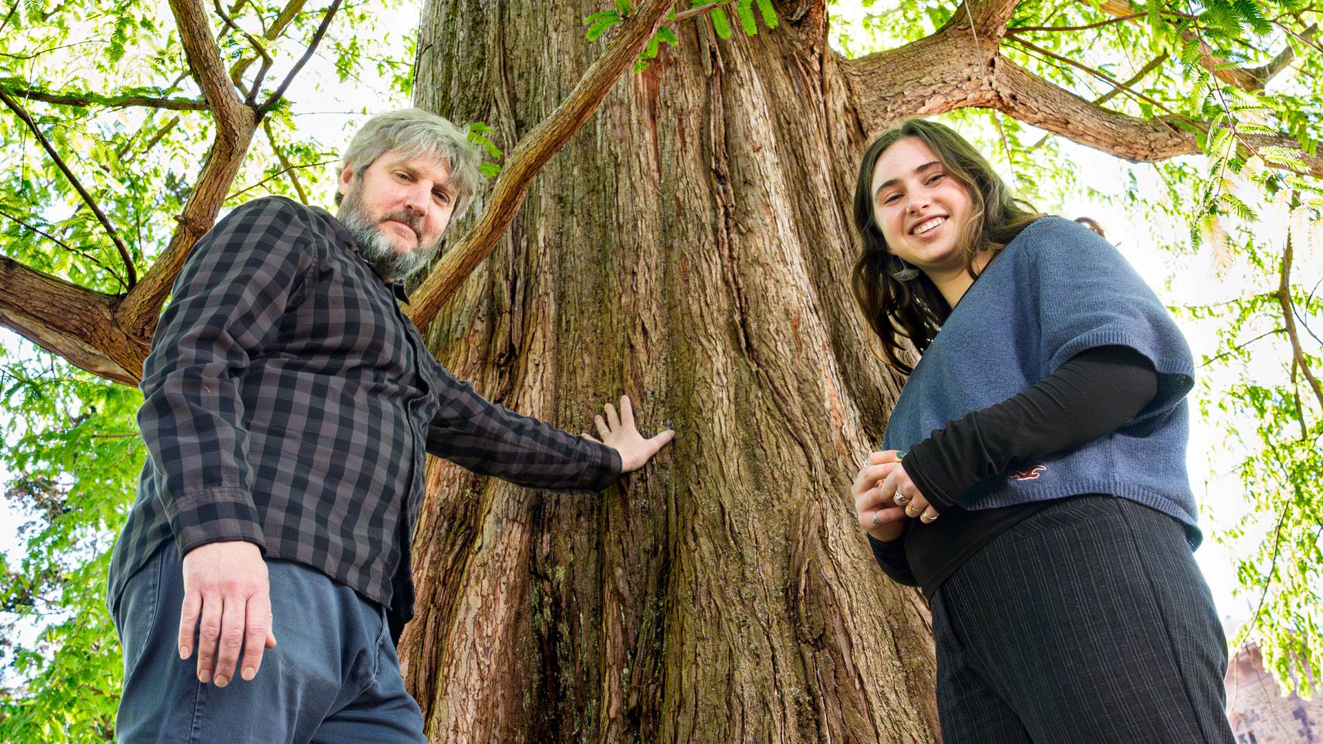 Professor John Higgins and senior Rio Baran at the base of a dawn redwood on campus.
