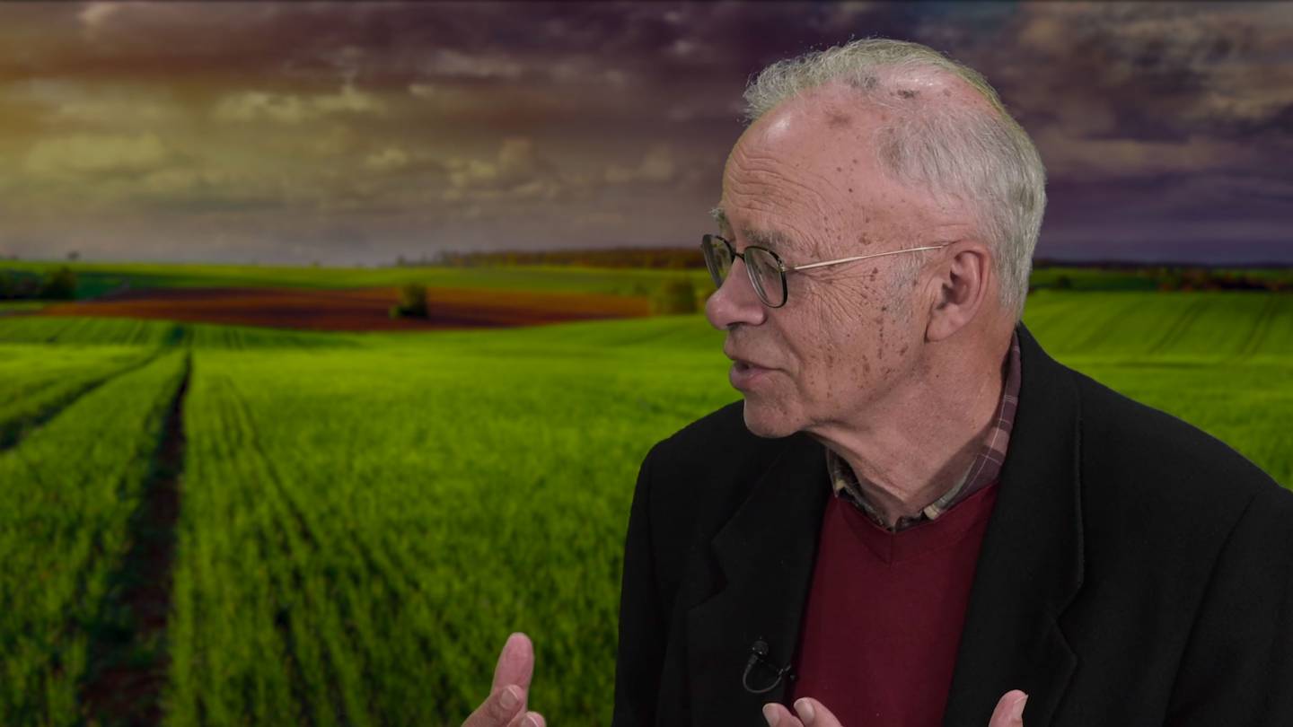 Peter Singer Speaks in front of a farm backdrop