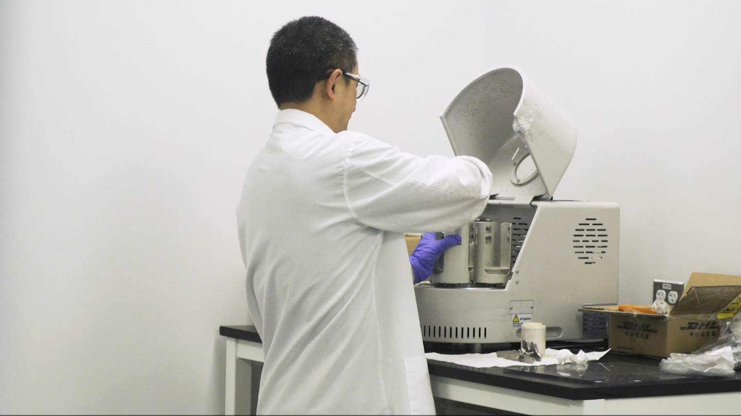 A researcher opens a machine