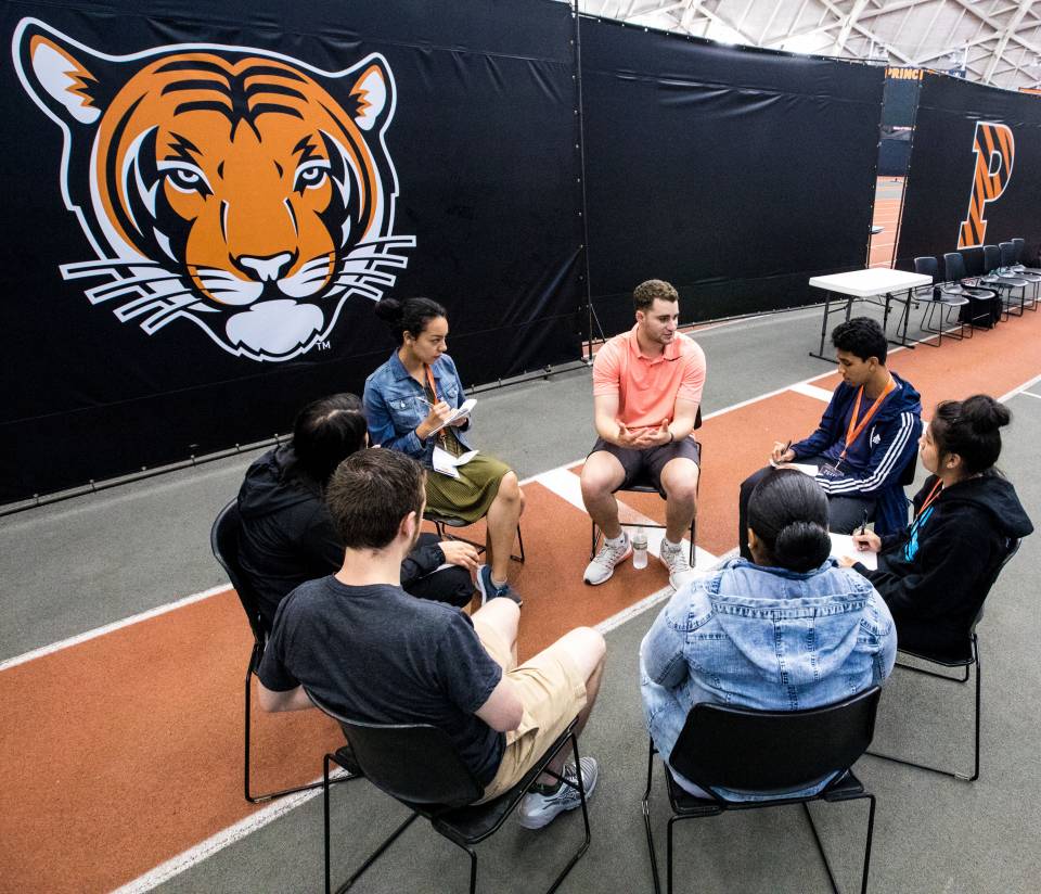 Students sitting in Jadwin Gym interviewing assistant basketball coach Skye Ettin