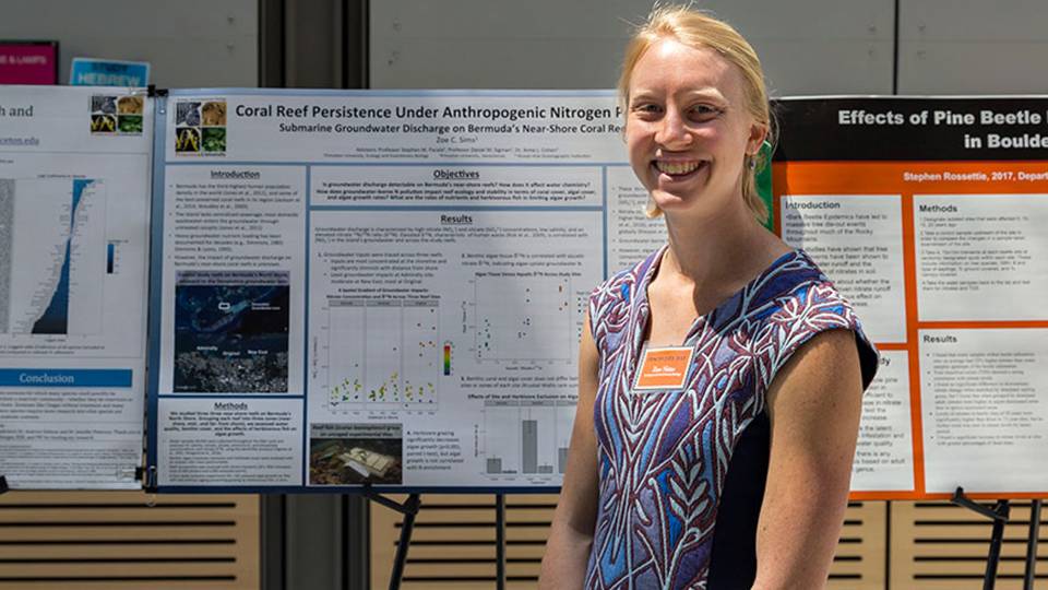 Zoe Sims standing in front of poster
