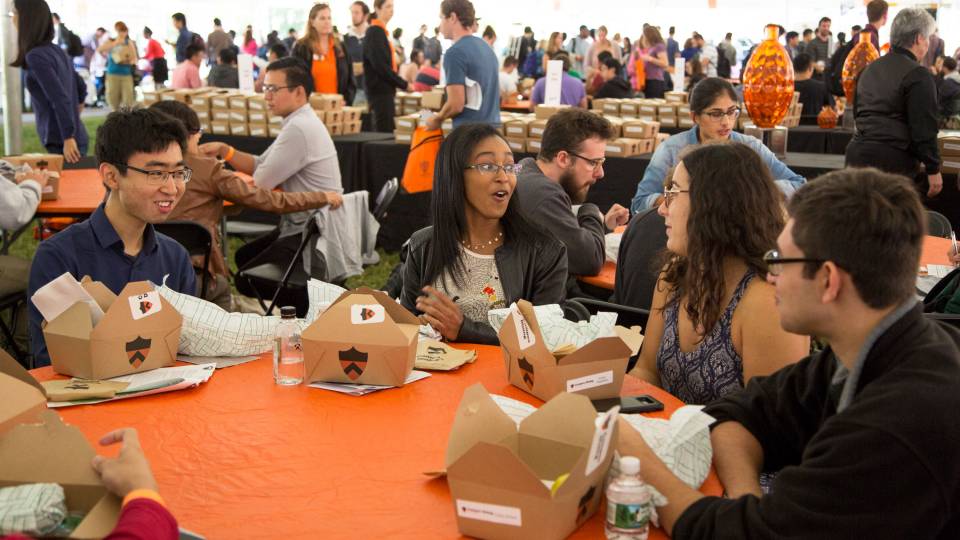 Graduate students sit around a table eating together
