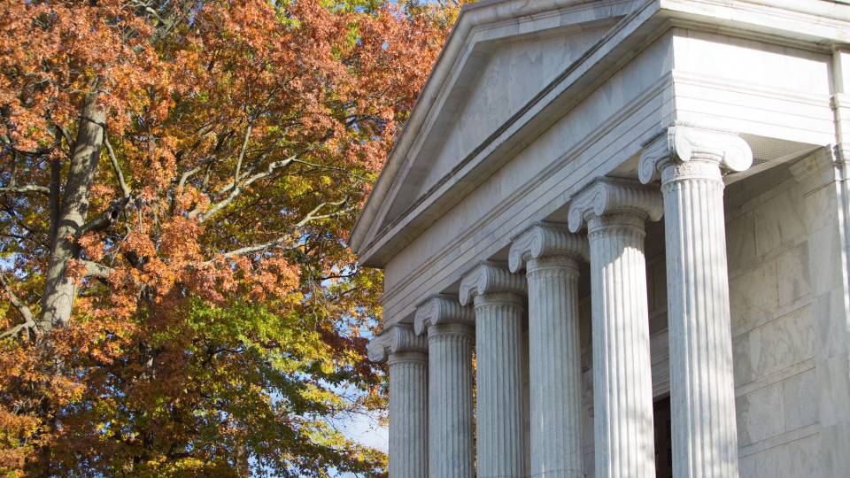 The columns of Whig Hall with autumn leaves in the background