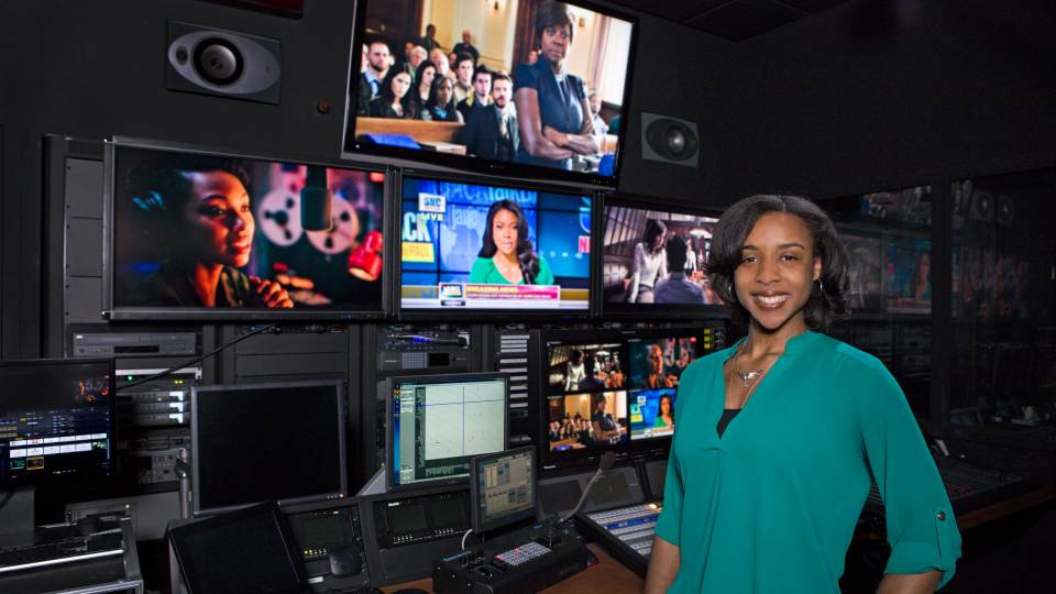 Taylor Griffith standing in front of TV screens