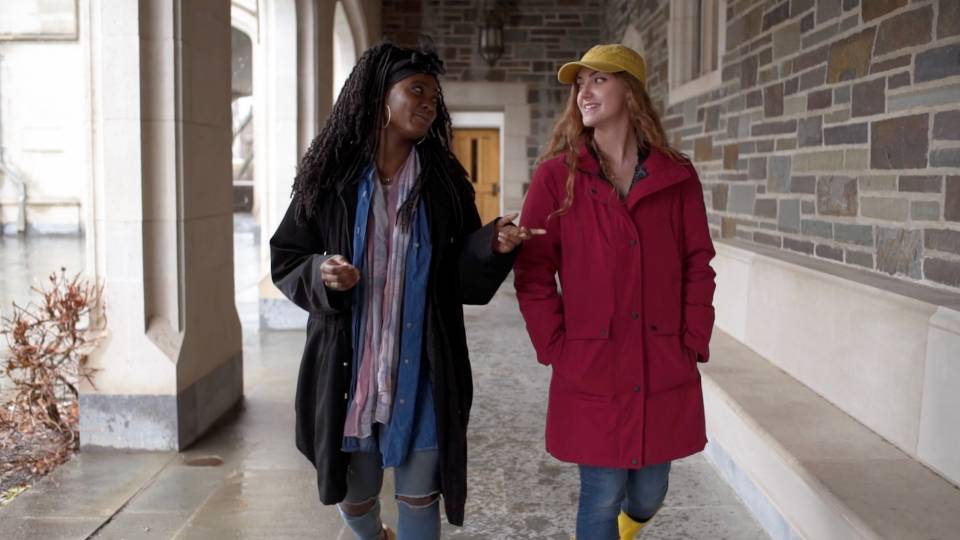 Two students walking together in breezeway