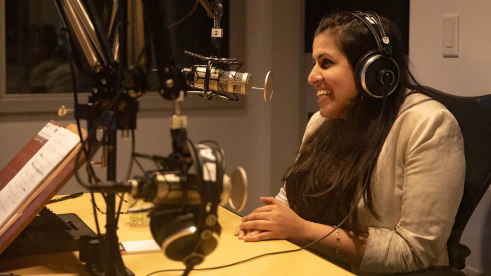 Sadaf Jaffer at mike recording podcast