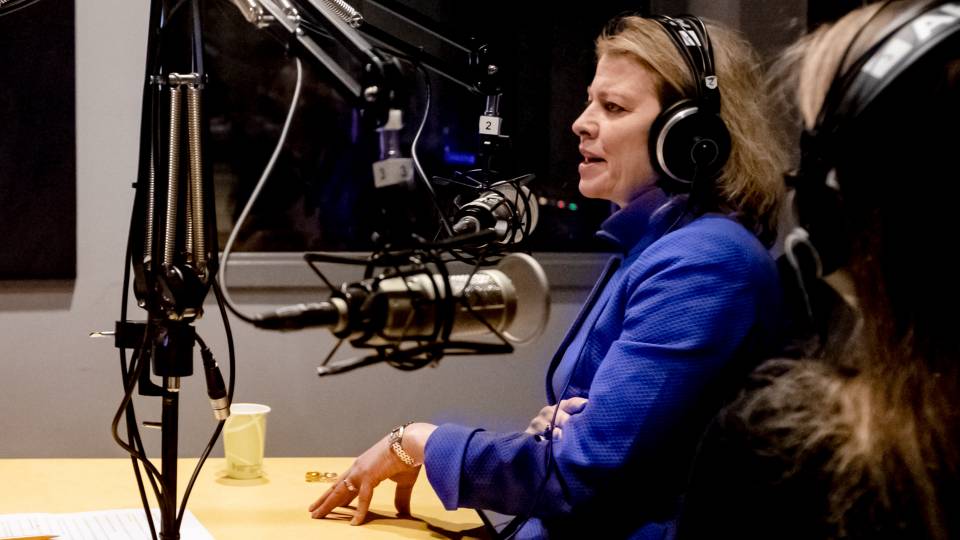 Biggins, wearing headphones, speaks in the recording studio