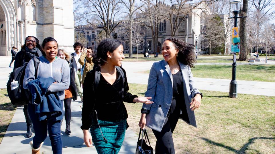 Autumn Womak walks with her student across campus