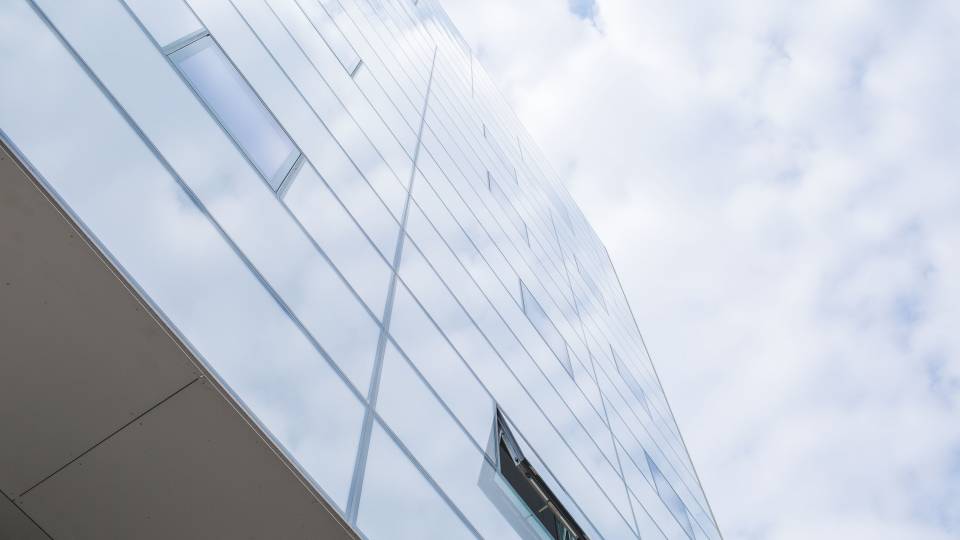 Building reflecting a cloudy sky