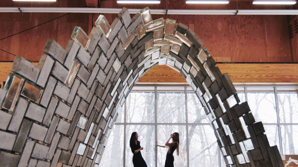 2 archictects stand under a robot-built tunnel