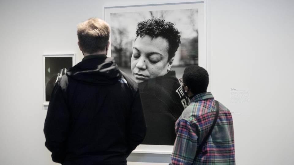 Visitors view the image "Nicole," by Elle Pérez, at Art on Hulfish gallery