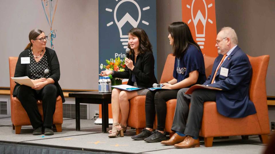 4 people sitting on a stage having a discussion
