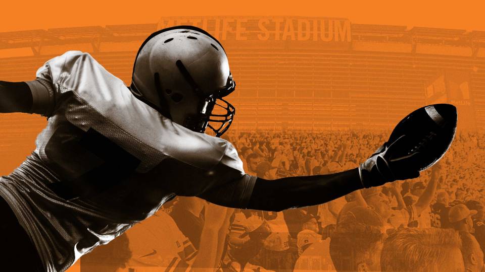 a football player lunges to catch the ball