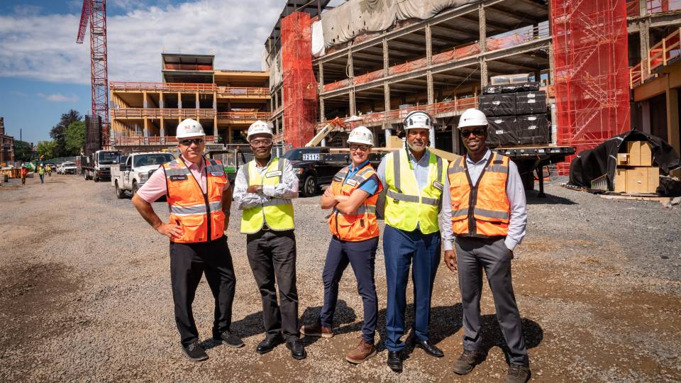 Workers wearing high-vis vests and hard hats at the SEAS Construction Site