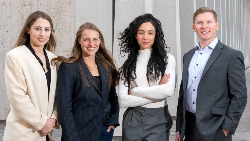 Four students in Princeton's School of Public and International Affairs pose in front of Robertson Hall.