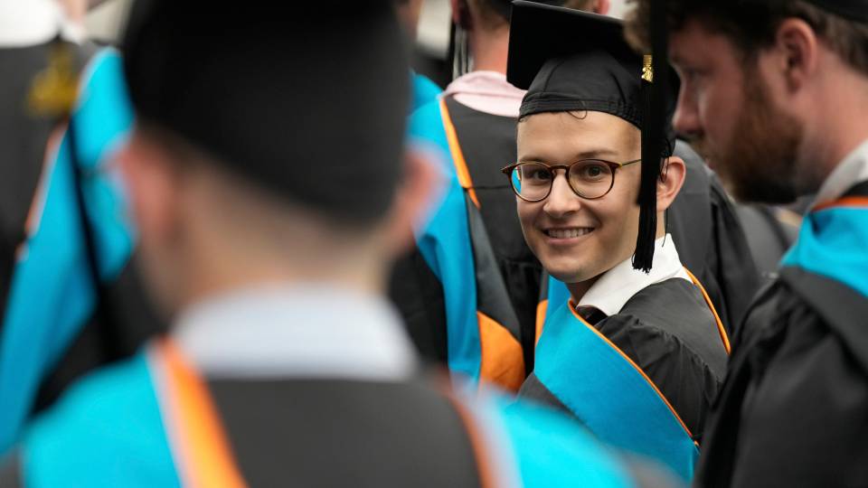 Smiling graduate student in cap and gown