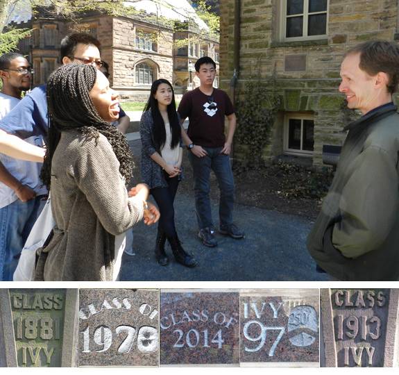 Class standing in front of Nassau Hall examining class year engravings