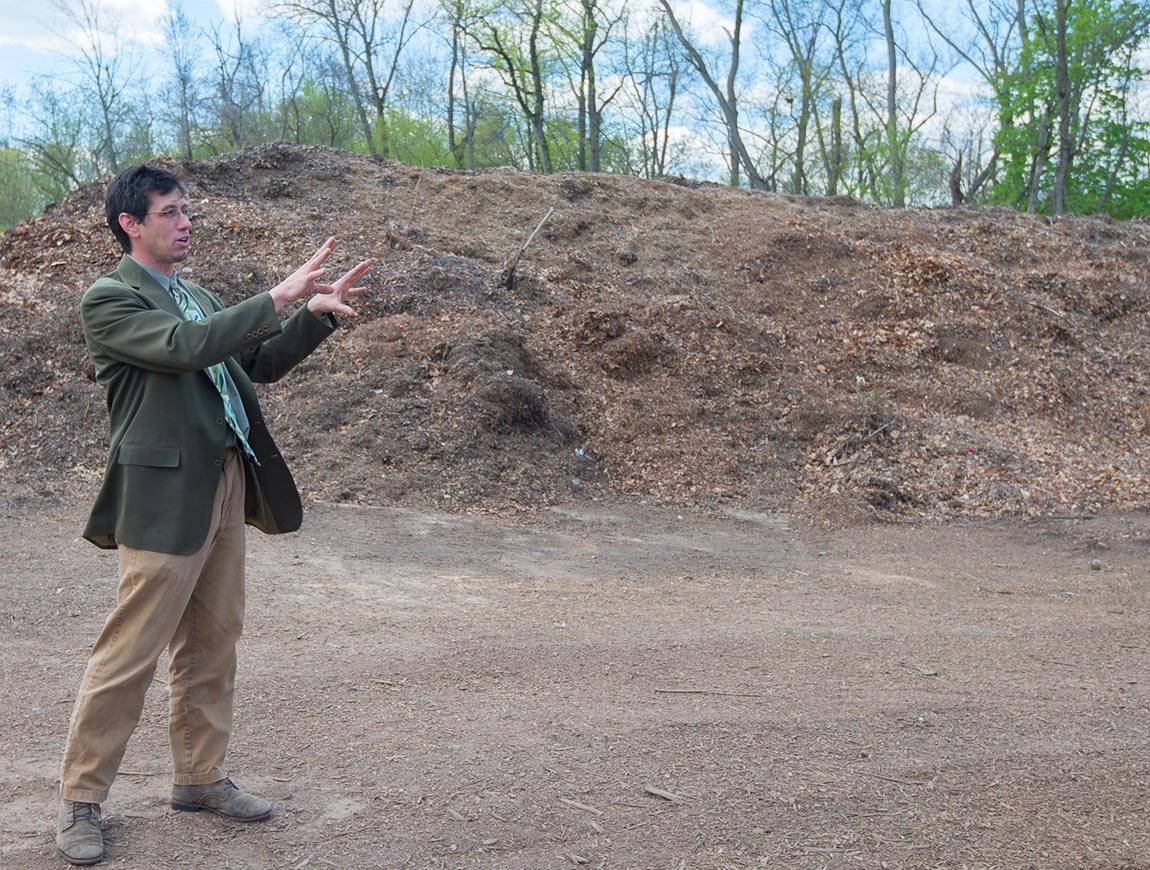 Greenhouse in front of mulch pile