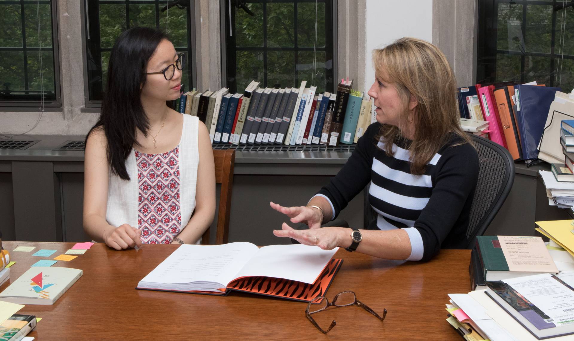 Jin Yun Chow sitting at table with professor Anna Shields 