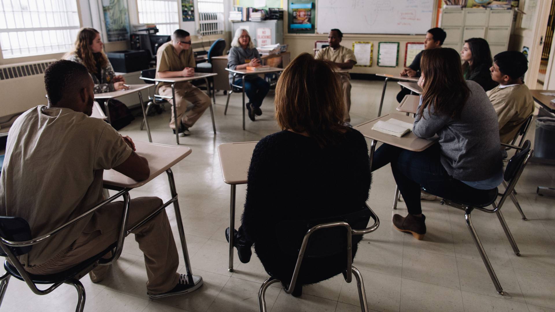 Students and faculty talking to inmates at correctional facility