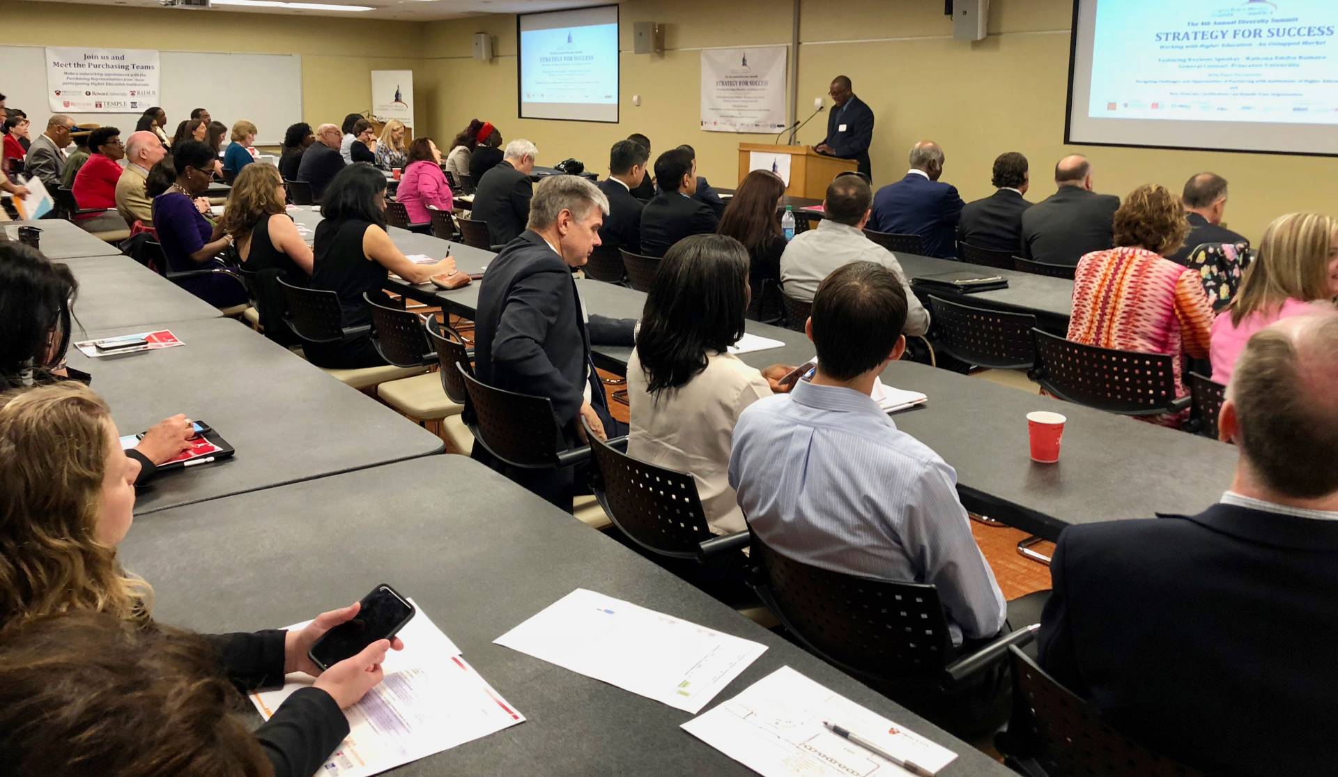 Audience listening to presenter at diversity summit vendor fair