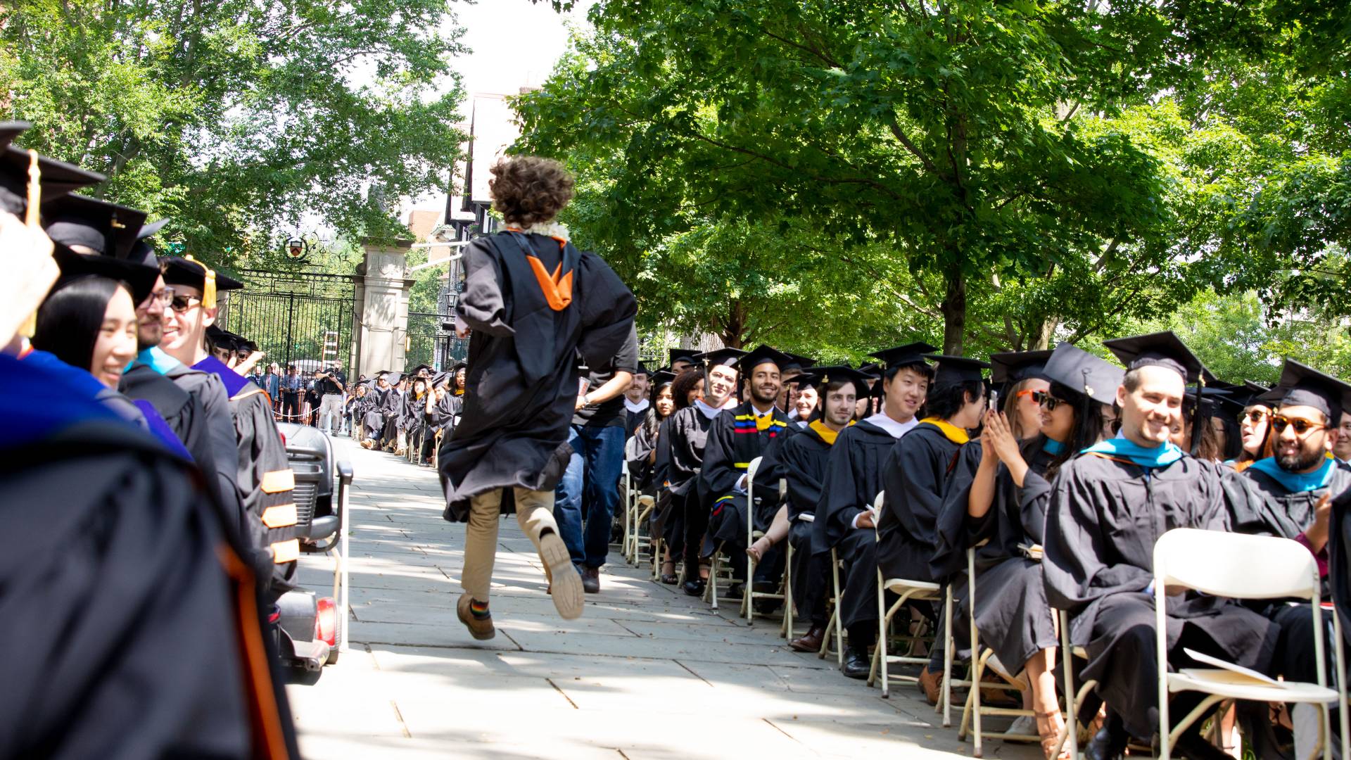 Kyle Berlin running down aisle at Comencement