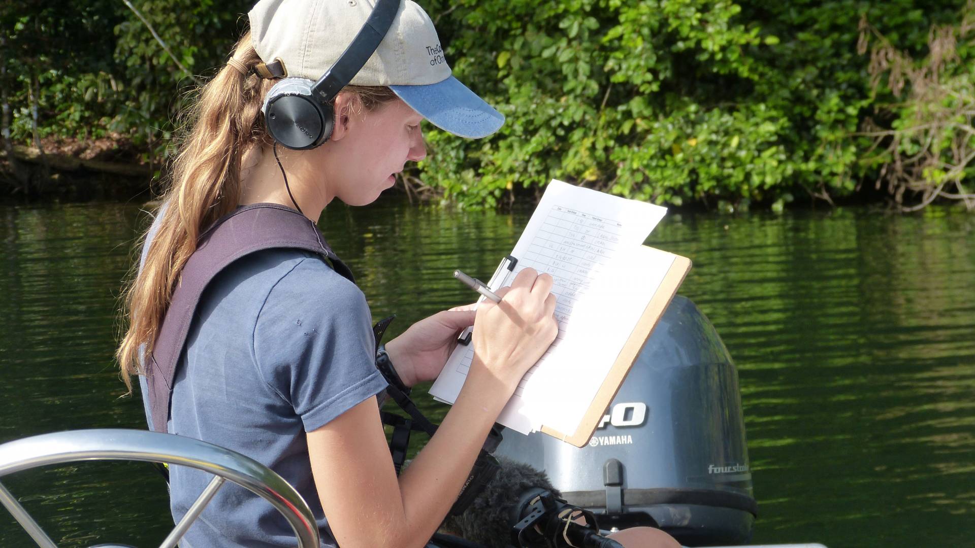 Amanda Savagian taking notes while sitting on a boat