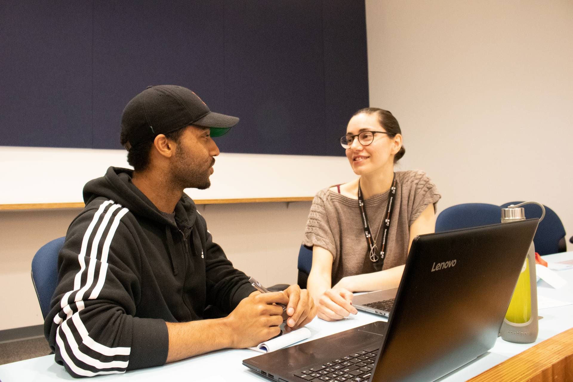 A postdoctoral student speaks with a presenter at a conference