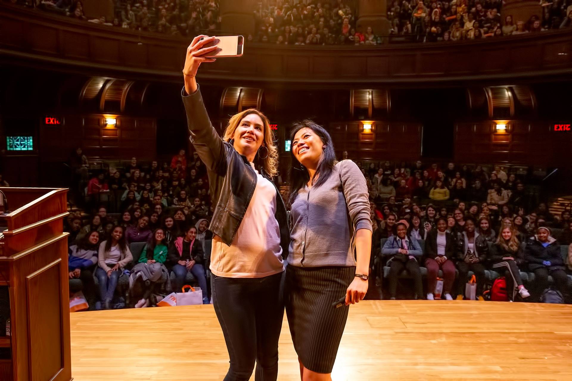 Deedee Ortiz taking a selfie on stage with Tammy Ma