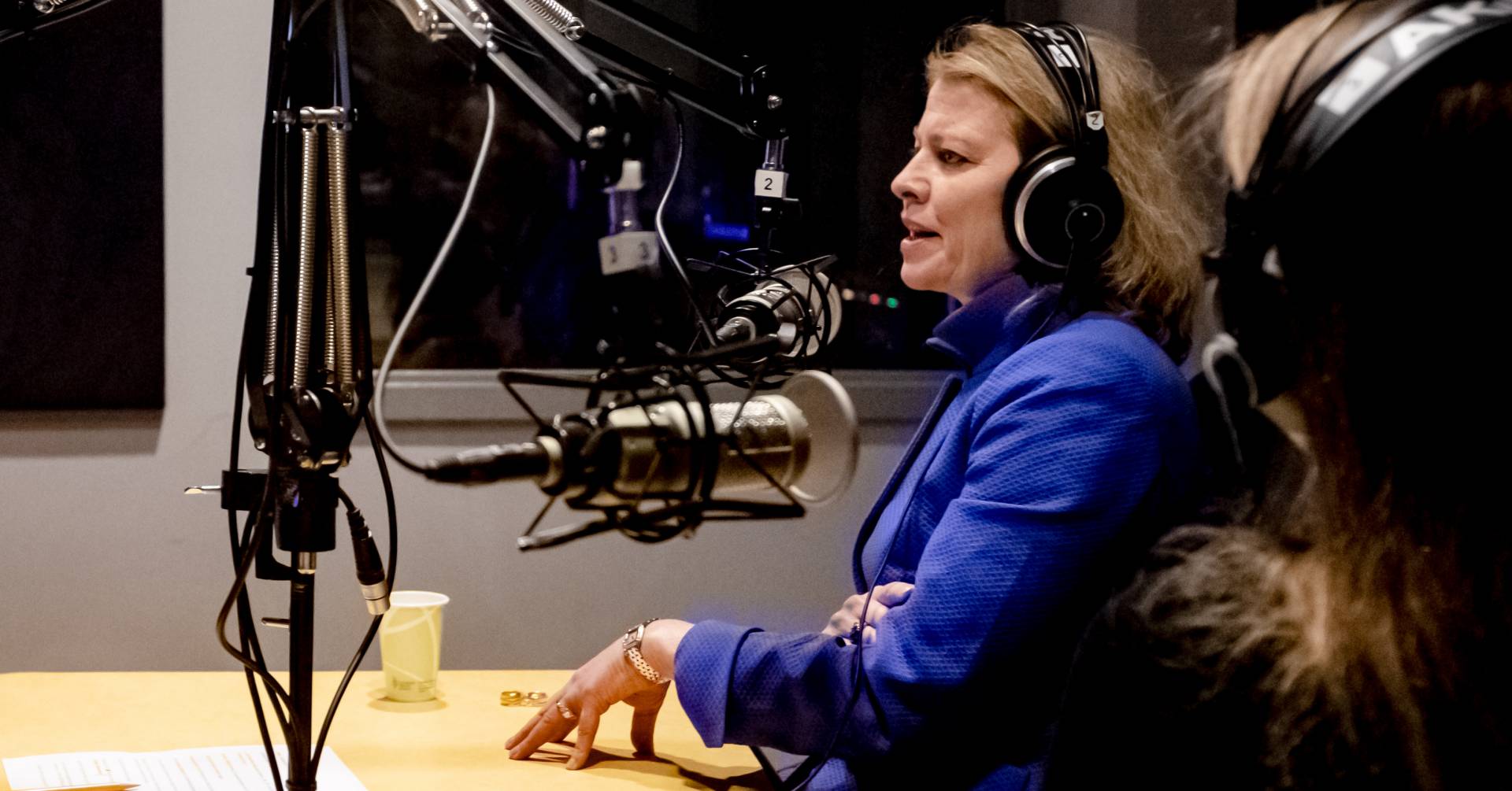 Biggins, wearing headphones, speaks in the recording studio