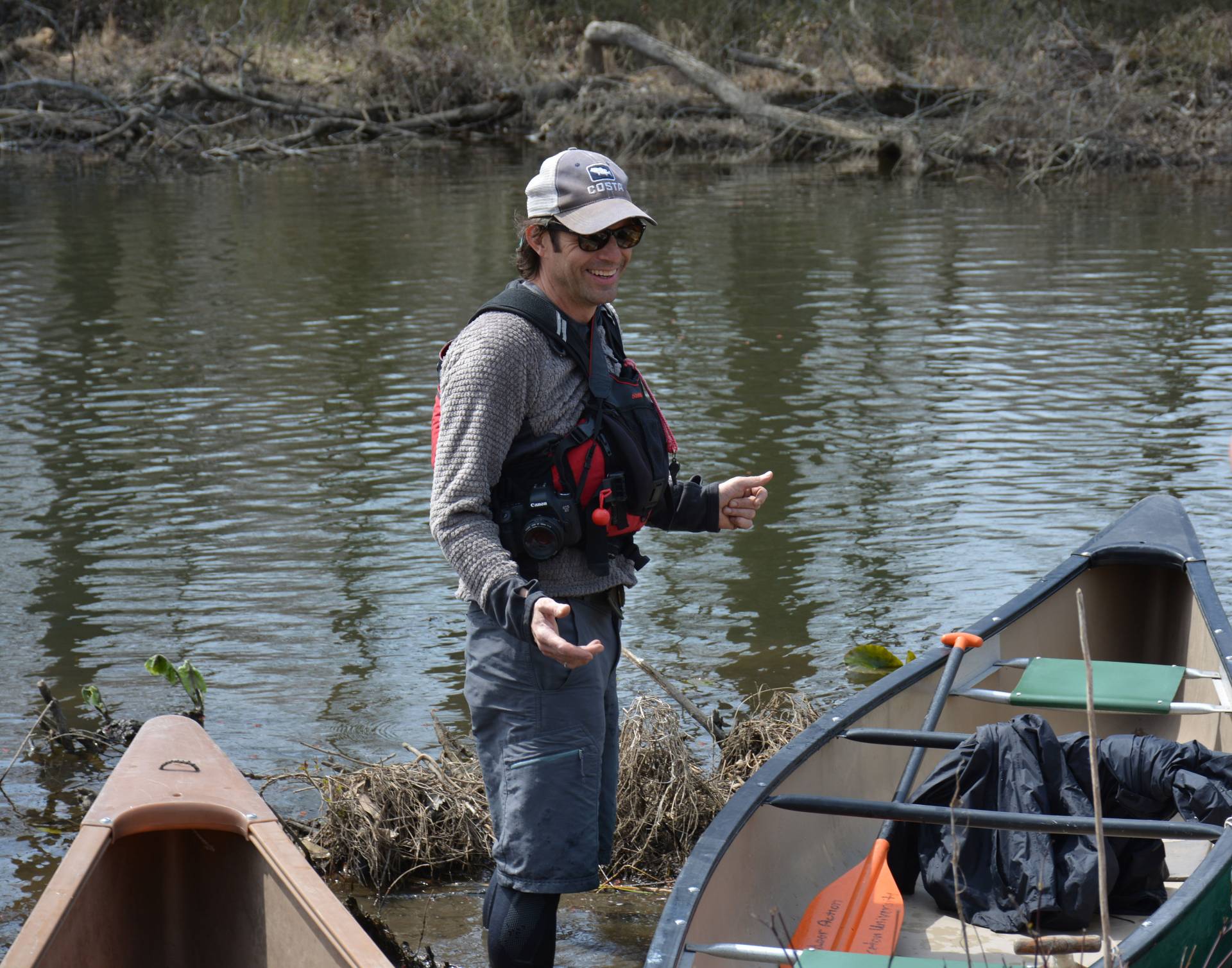 Jeff Whetstone gestures in front of canoes
