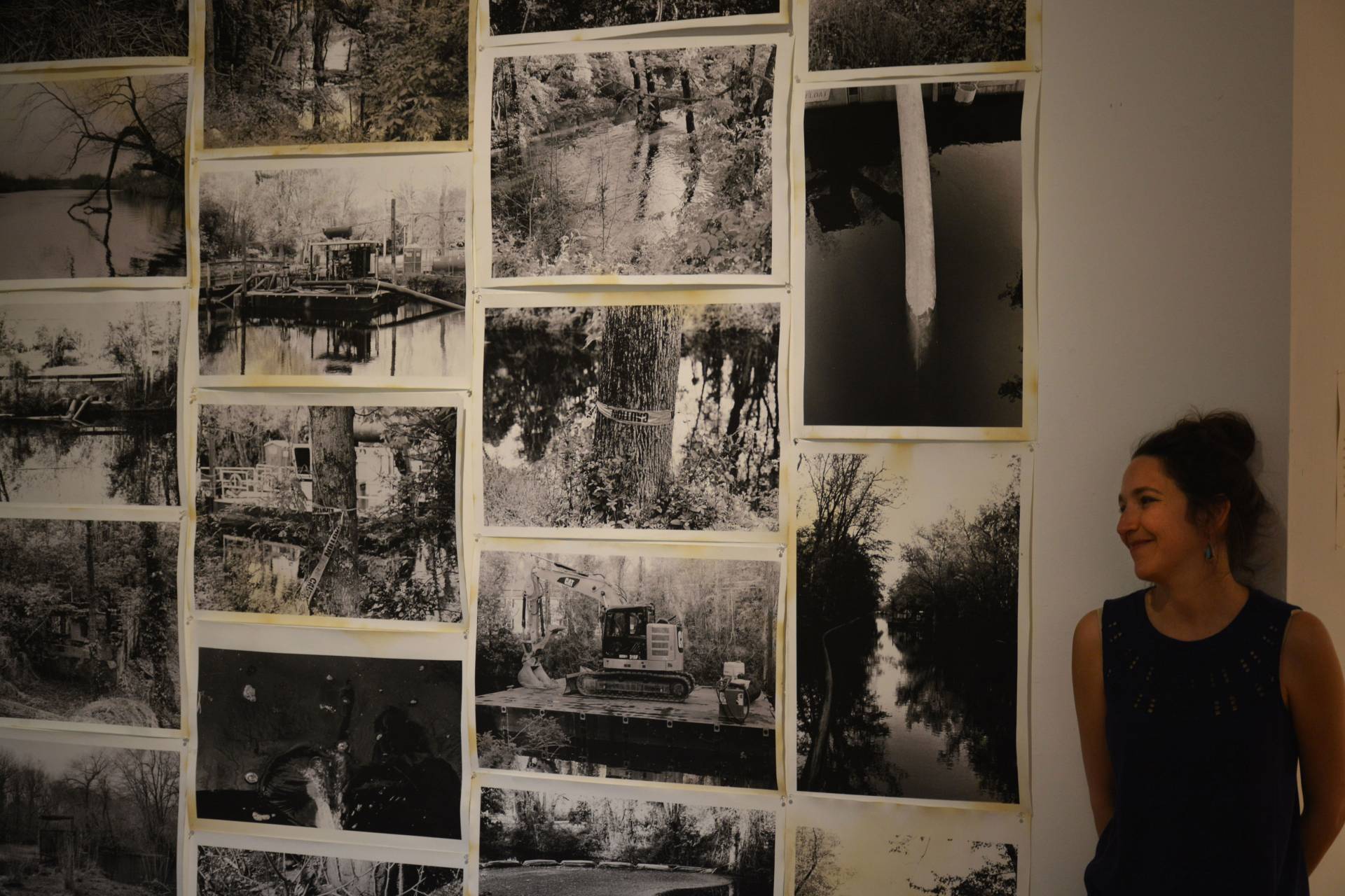 Nomi Stone stands next to a wall of black and white photos