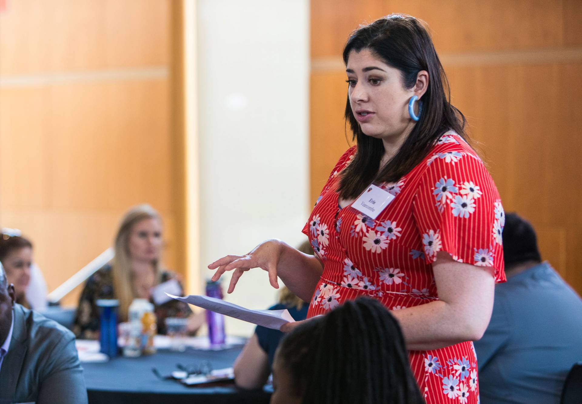 Erin Vancombe speaking to a table of people