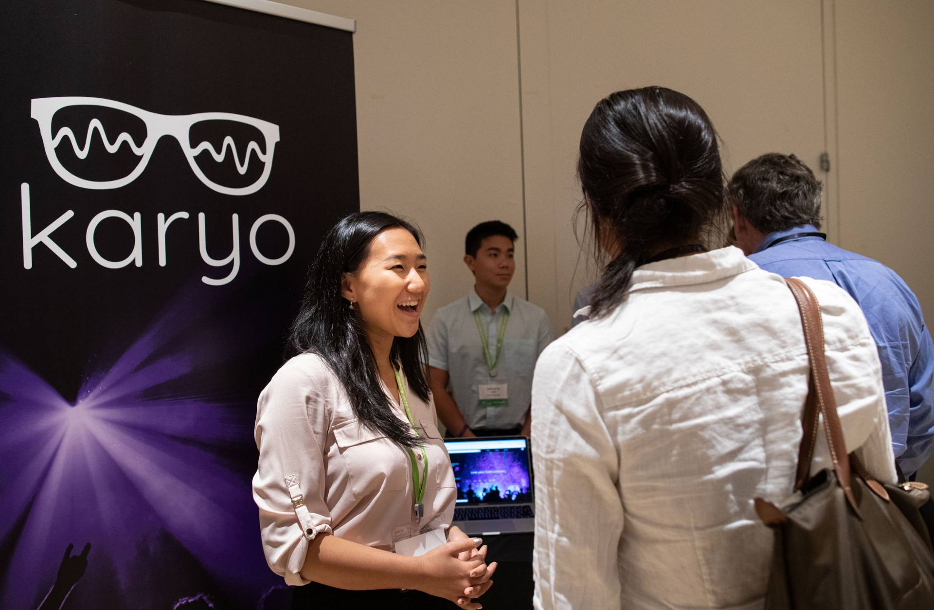 Christa Lee speaking in front of a banner for Karyo