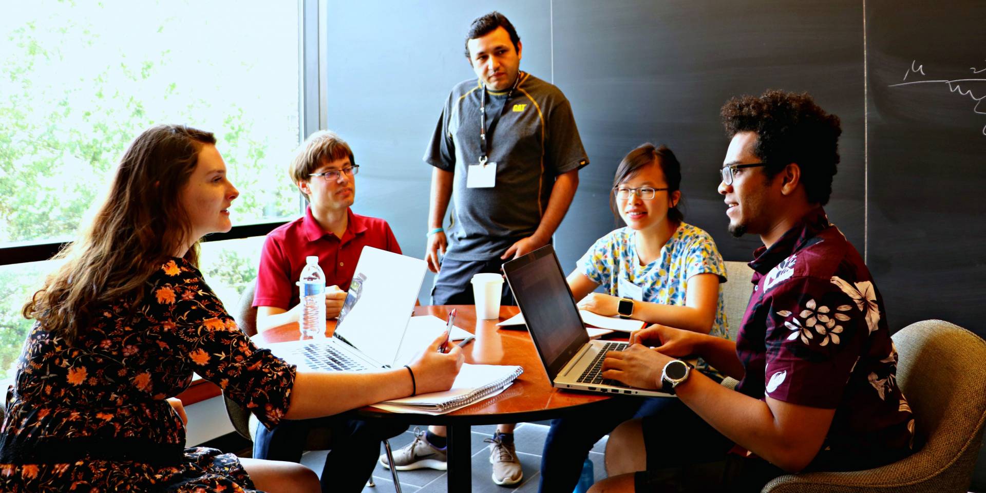 Students and researchers gather around a table