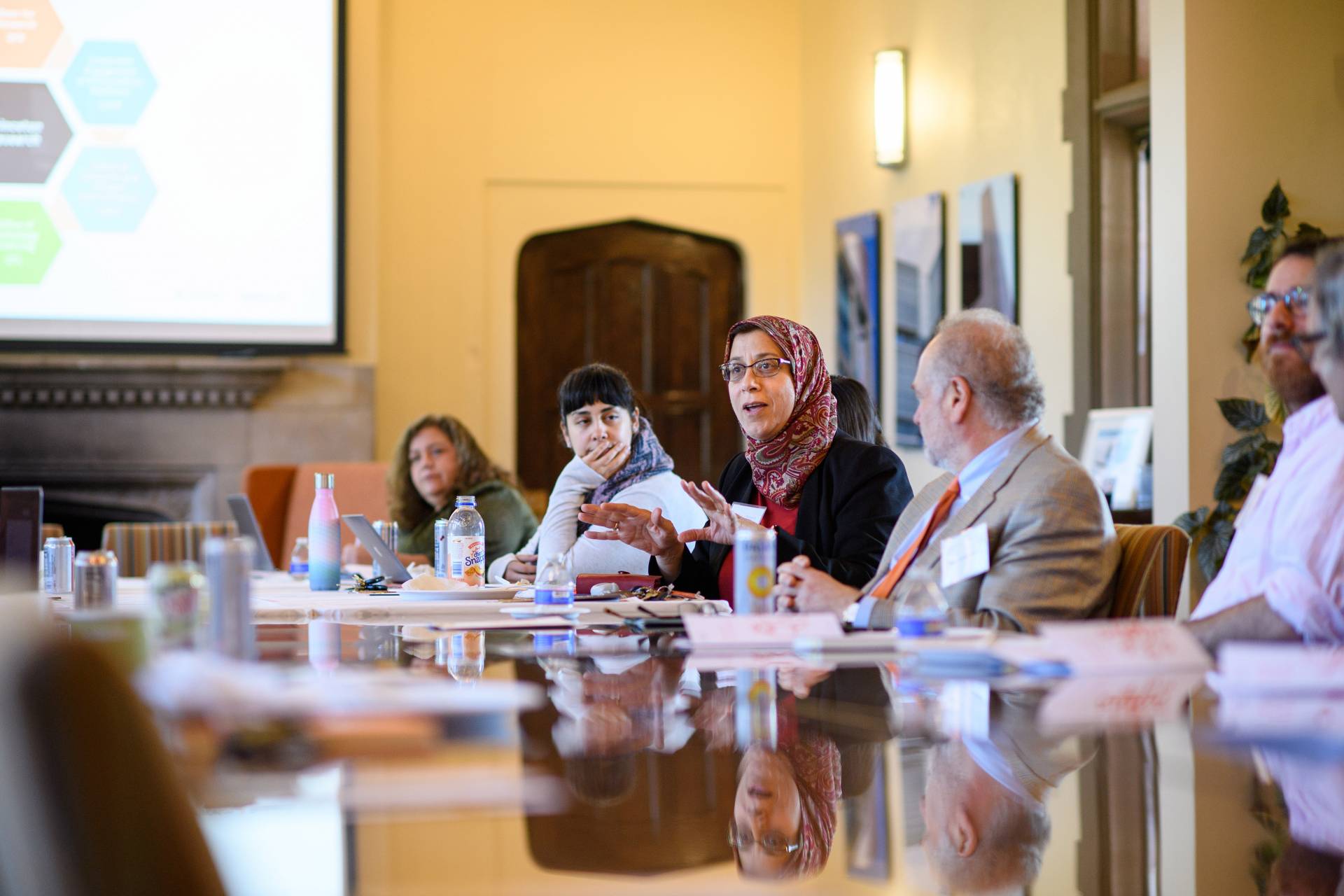 Faculty speak while sitting around a table