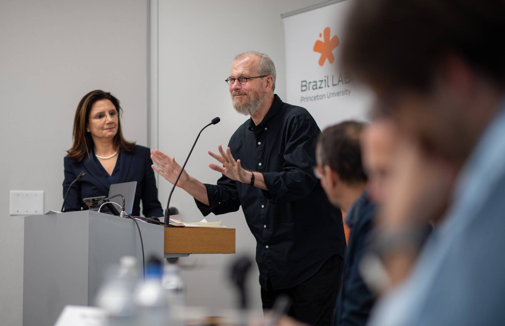 João Biehl holds up his hands at a podium